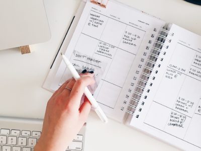 Hand on planner at desk