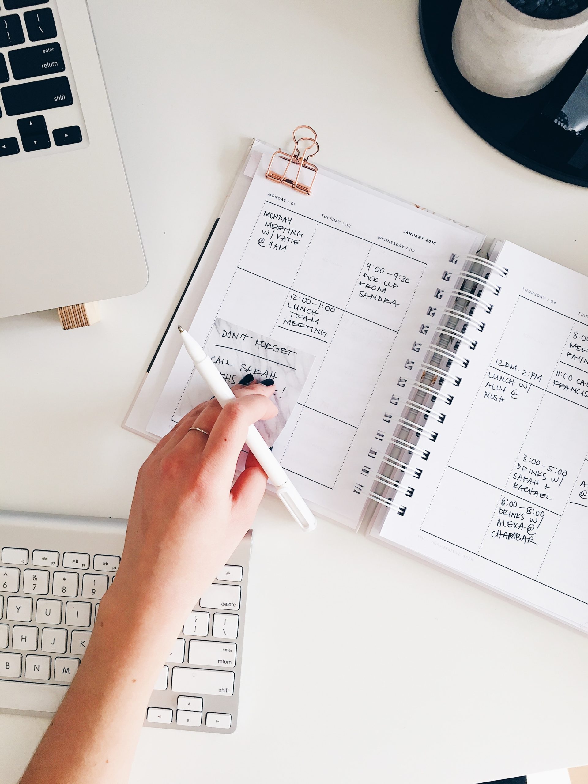 Hand on planner at desk